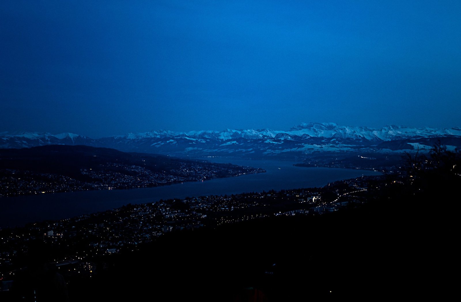 Night view over a Swiss lake and snow-covered mountains